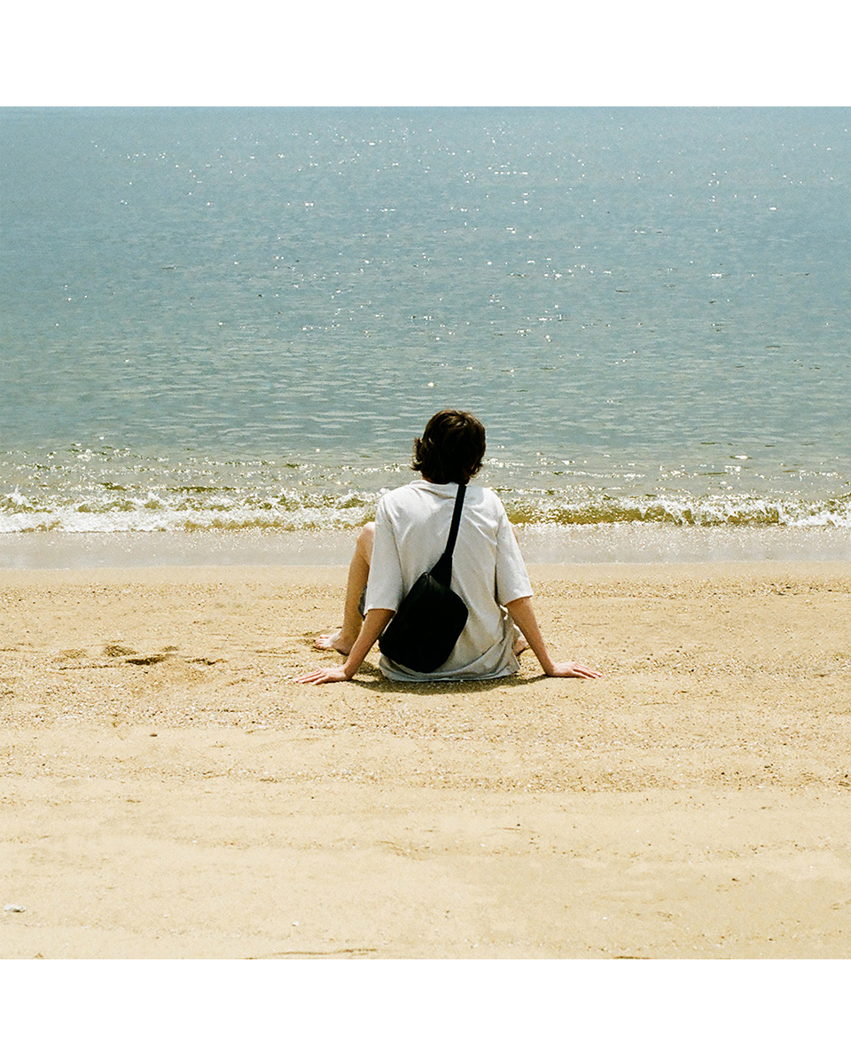 VU deer leather body bag, relaxed styling on beach, everyday use